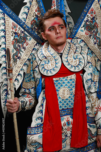 Chinese traditional warrior male costume at studio over grey background. Handsome man wearing national costume in Beijing, China