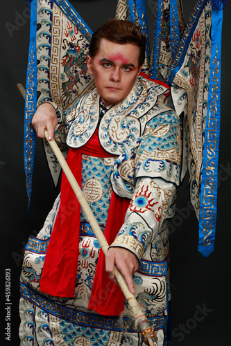 Chinese traditional warrior male costume at studio over grey background. Handsome man wearing national costume in Beijing, China