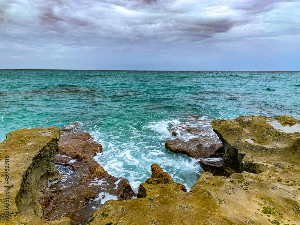 waves crash onto rocky shore on the beach waves crash onto rocky shore on the beach