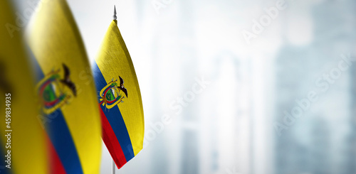 Small flags of Ecuador on a blurry background of the city