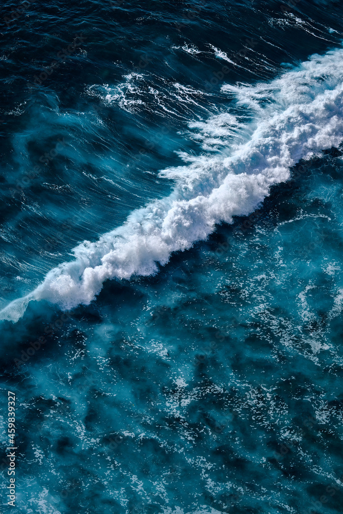 Aerial view to seething waves with foam. Waves of the sea meet each other during high tide and low tide - obrazy, fototapety, plakaty 