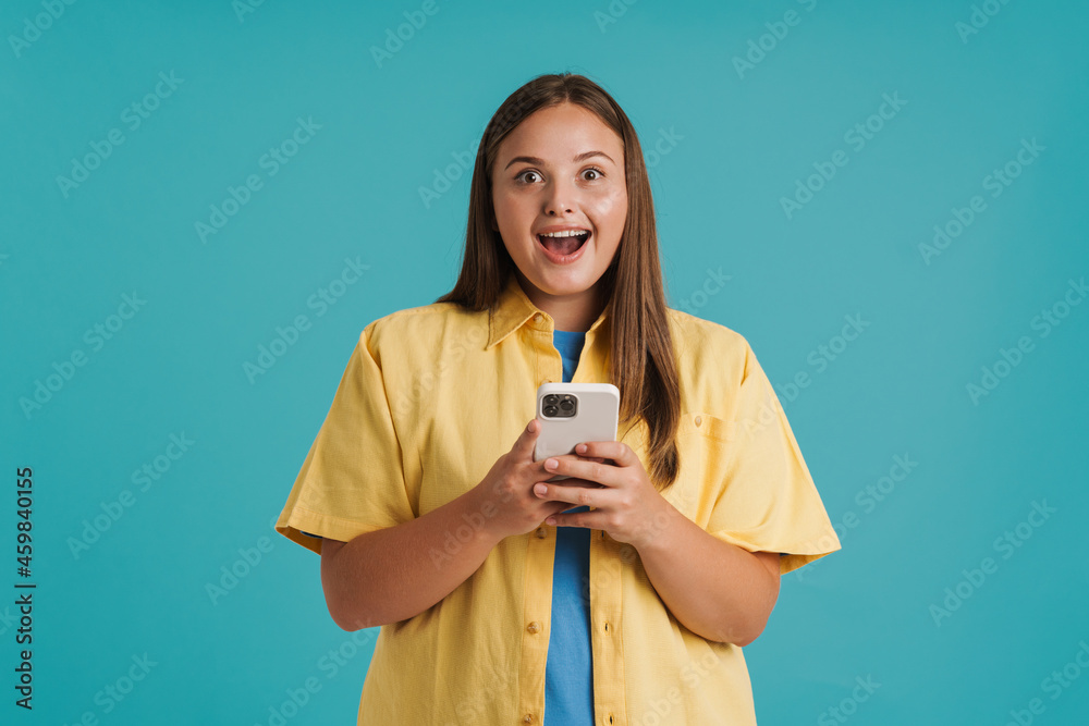 Young white woman expressing surprise and using cellphone Young white woman expressing surprise and using cellphone