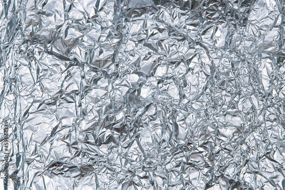 Silver shiny crumpled foil texture background. Top view Silver shiny crumpled foil texture background. Top view