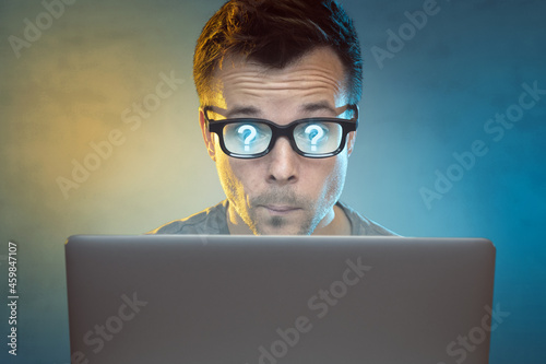 Wondering man in front of a laptop monitor