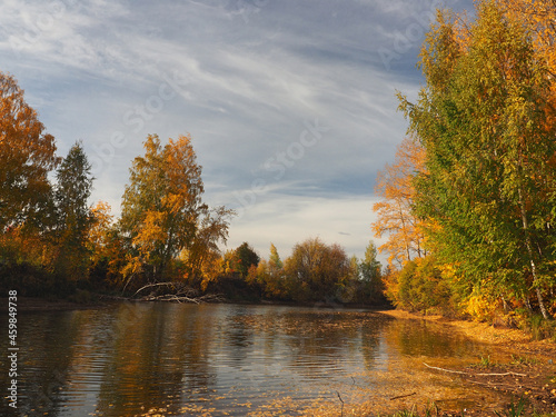 Autumn. Autumn trees in the park. River bay with floating leaves. Beautiful sky. Russia, Ural, Perm region