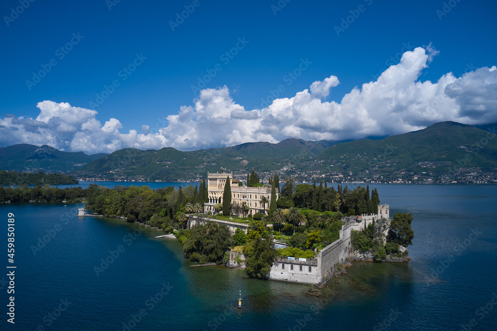 Isola del Garda, Italy. An island surrounded by the Italian Alps. Magnificent aerial panorama of Isola del Garda, Lake Garda, Italy. Castle on an island in Italy. Historic sites on Lake Garda.