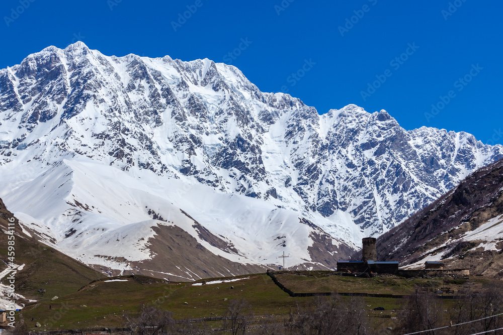 View of the Ushguli village at the foot of Mt. Shkhara. Lamaria Monastery, old Rock tower