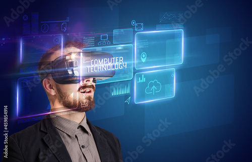 Businessman looking through Virtual Reality glasses, tech concept