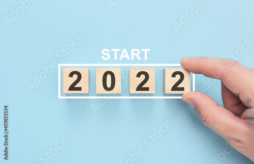 New start 2022 concept. Loading new year 2022 with hand putting wood cube in progress bar. Happy new year 2022. Start concept