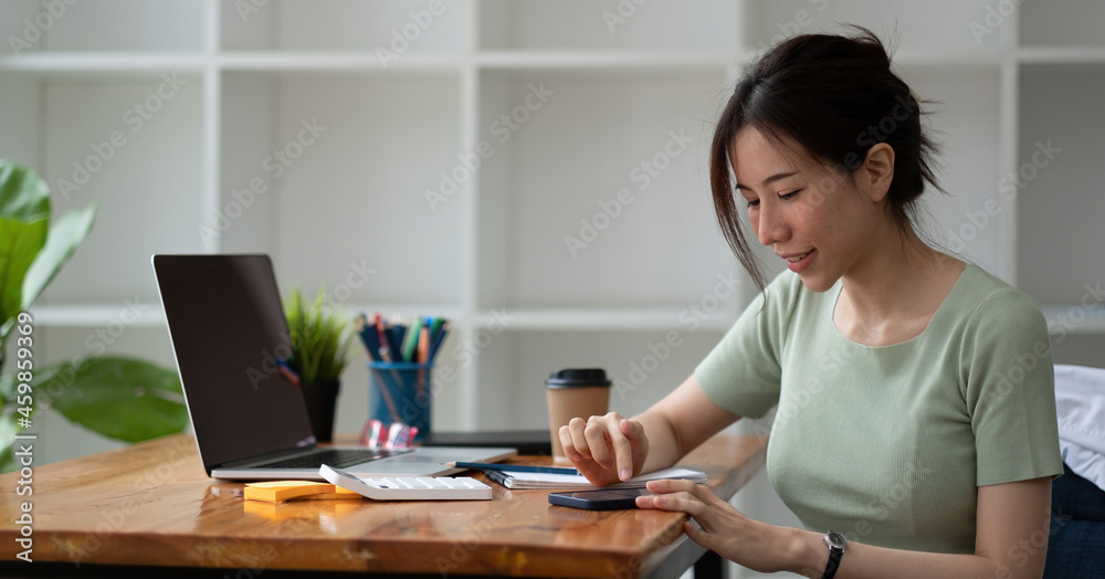 Close up hand of happy asian woman using mobile phone on working desk, business accounting concept Close up hand of happy asian woman using mobile phone on working desk, business accounting concept