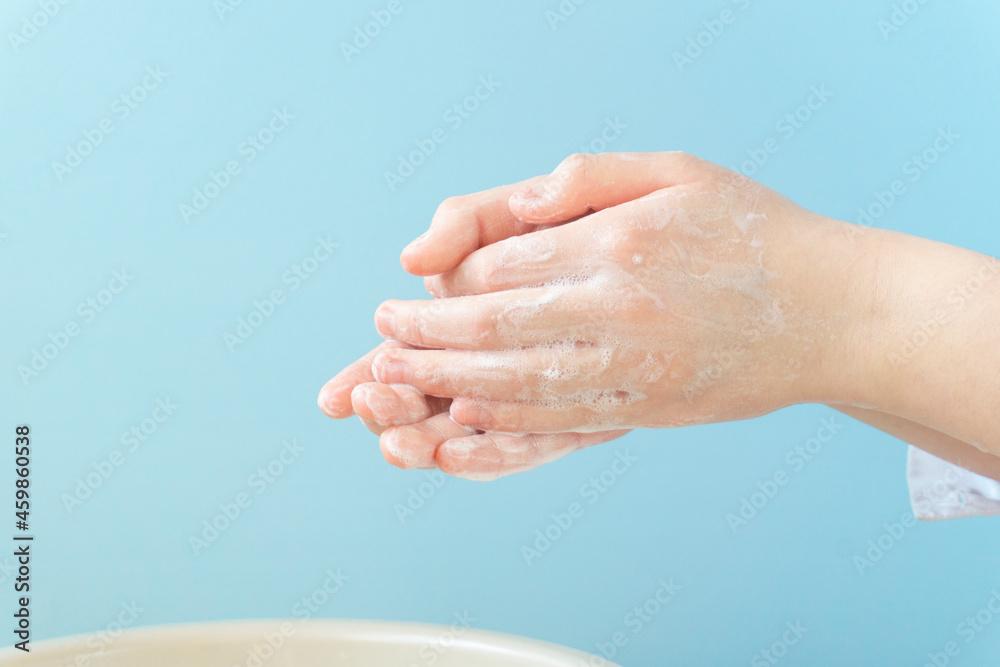 Fototapeta premium The child who washes a hand with soap. Close up of the girl of the hand 石鹸で手を洗う子供。女の子の手のクローズアップ。