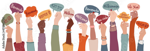 Raised arms and hands of multi-ethnic people from different nations and continents holding speech bubbles with text -Welcome- in various international languages.Communication. Community photo