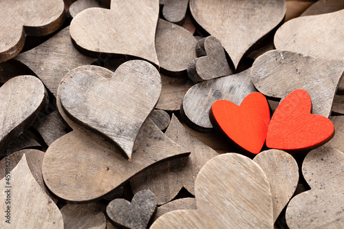 Wooden hearts, one red heart on the heart background..