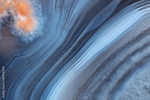 Φωτογραφία The texture of a beautiful blue striped agate with an orange inclusion