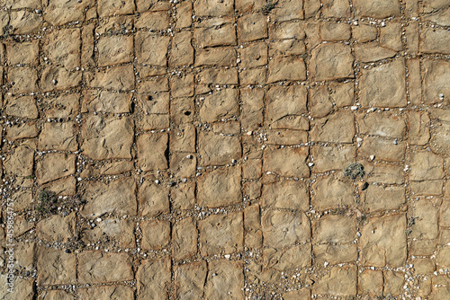 The texture of raw blocks of yellow sandstone pavement.