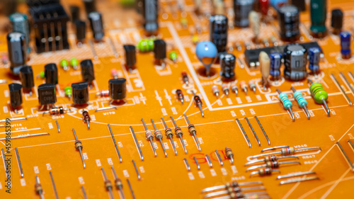 Принти на полотні An old orange printed circuit board with multicolored electronic components, horizontally panoramic