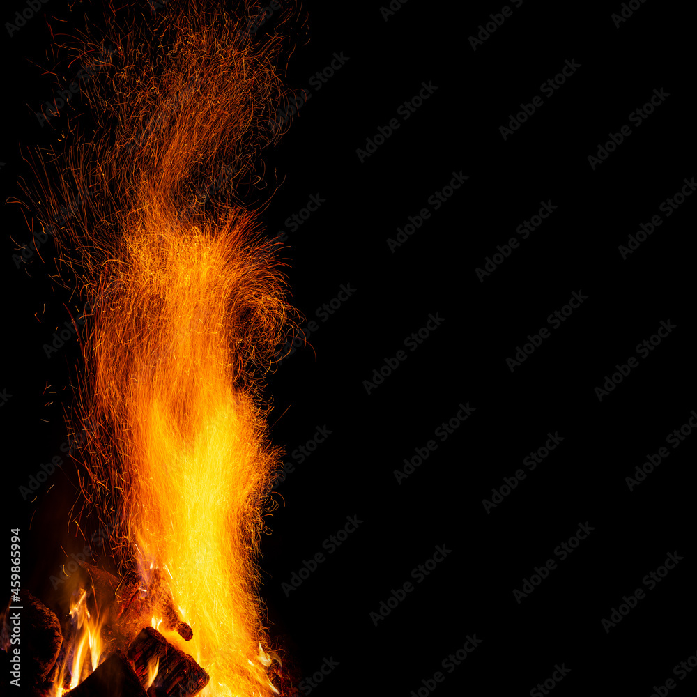 A bonfire with a column of sparks on a black background with a free space, a square frame.