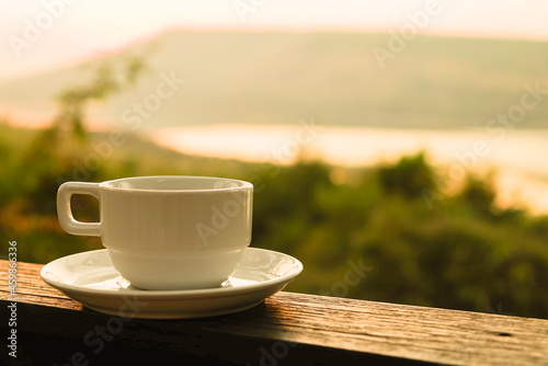a white cup of coffee with on sunrise time