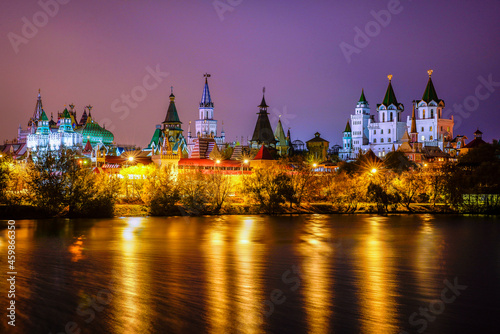 Panorama Izmailovo Kremlin buildings with turrets are illuminated by evening illumination against the background of a beautiful evening lilac embankment, on the banks of the reservoir the river.