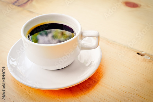 a white cup of coffee on the table With color effect