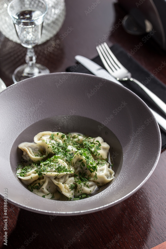 Homemade meat dumplings with parsley russian pelmeni and vodka shot on the table Homemade meat dumplings with parsley russian pelmeni and vodka shot on the table