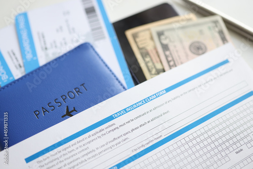 Travel medical insurance passport and money on table closeup