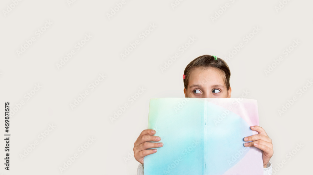 child girl holding a book in her hands with surprised looks out from behind the book.Back to school. Interesting book.
child girl holding a book in her hands with surprised looks out from behind the book.Back to school. Interesting book.