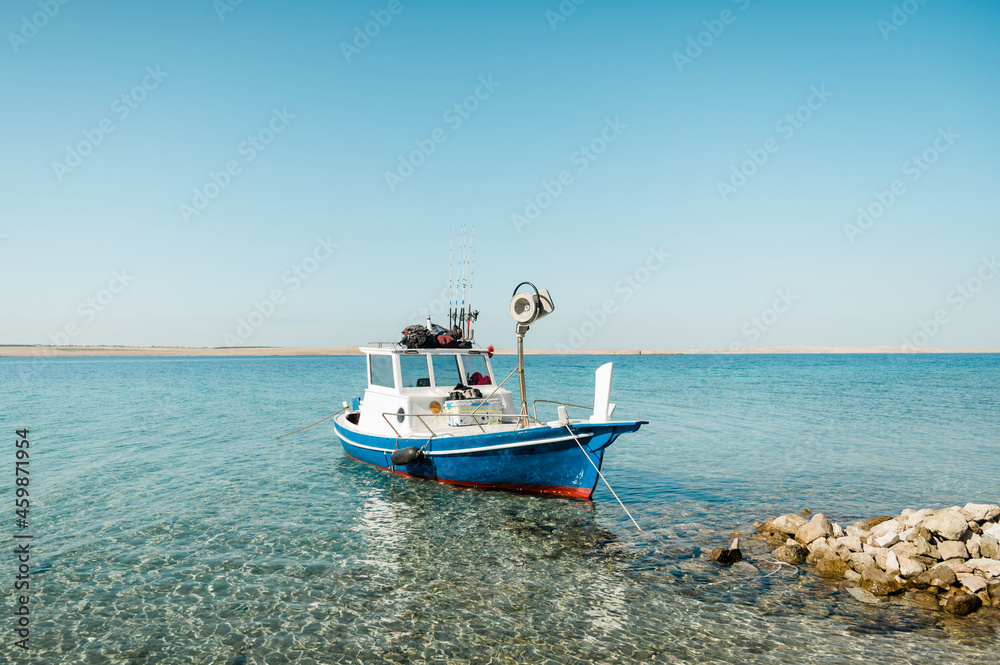 Fishing boat next to the beach in Croatia. Beautiful summer day, crystal clear water.