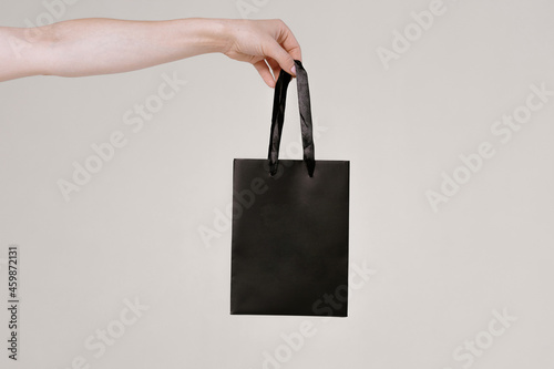 black package in hands on a white background
