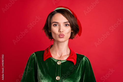 Photo of charming romantic cute lady lips send air kiss wear elf costume hat isolated red color background