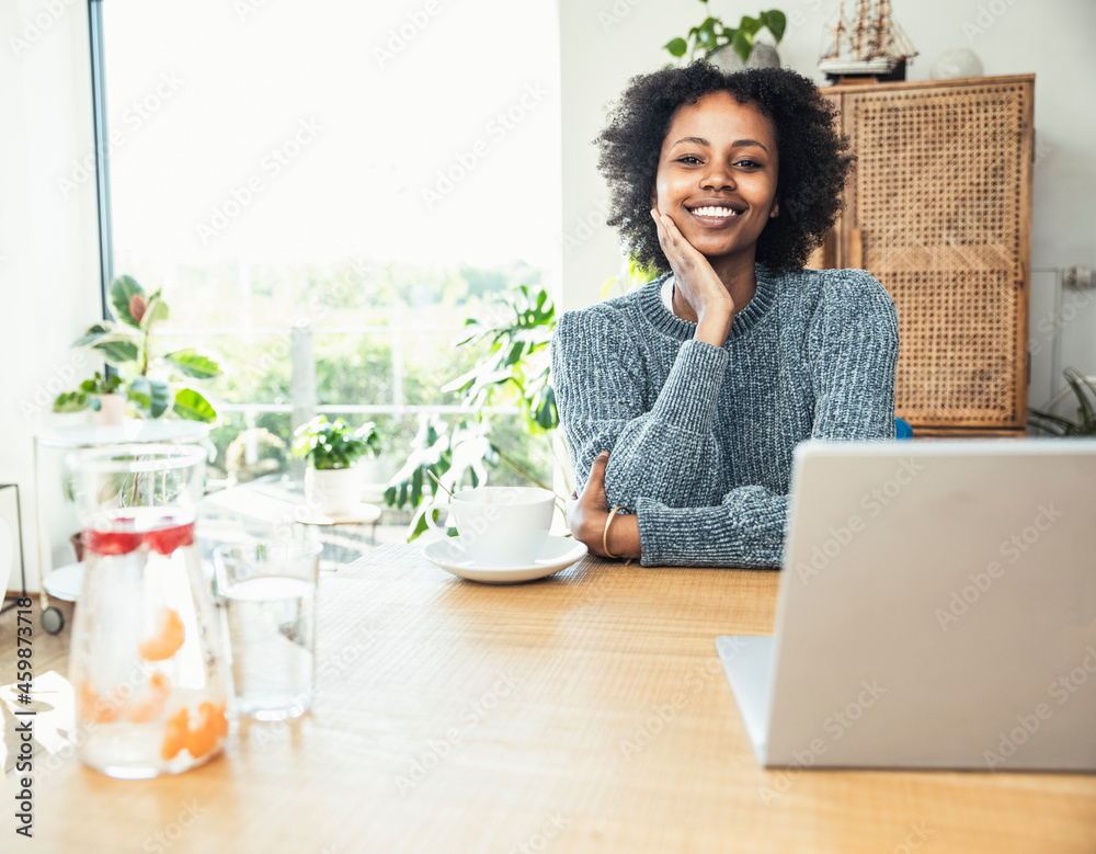 Smiling female professional with hand on chin sitting at desk Smiling female professional with hand on chin sitting at desk