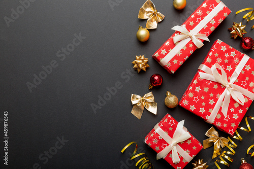 Holiday flat lay with gift boxes wrapped in colorful paper and tied decorated with confetti on colored background. Christmas, Birthday, Valentine and sale concept, top view