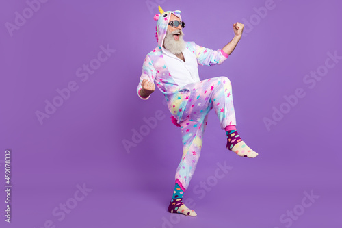 Full length body size view of attractive cheerful man in pajama rejoicing isolated over violet purple color background photo