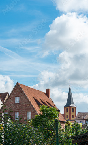Old German houses and church under a sunny cloudy sky. Ilvesheim, Germany