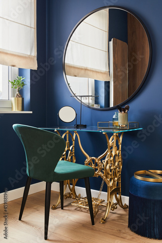 Stylish composition of woman corner in modern glamour interior design with vanity table, big rounded mirror and beautiful personsl accessories. Template. photo