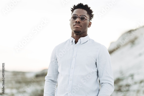 Portrait of handsome fashionable african american man, in white shirt, man posing outdoors
