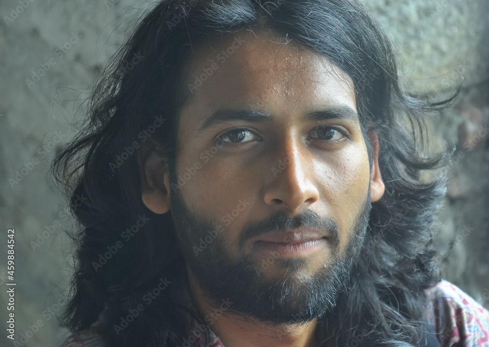 Close up shot of a attractive Indian young man face with beard and long hair.  A guy looking at camera Stock Photo | Adobe Stock