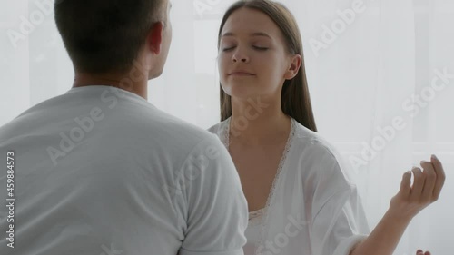 Calm Young Couple Practicing Yoga At Home, Meditating Together In Bed