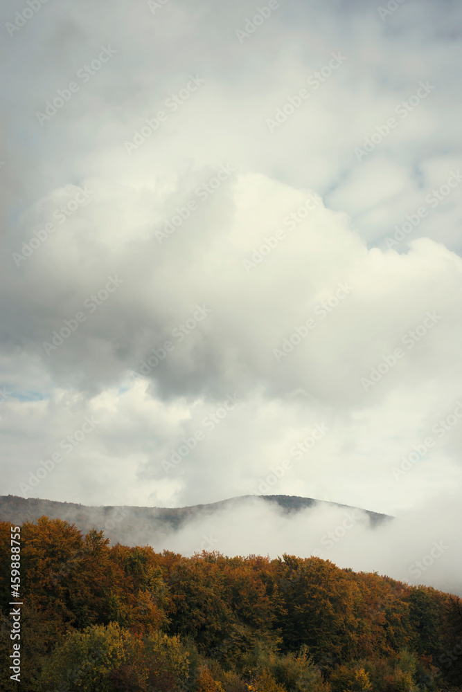 clouds over mountain and forest in autumn