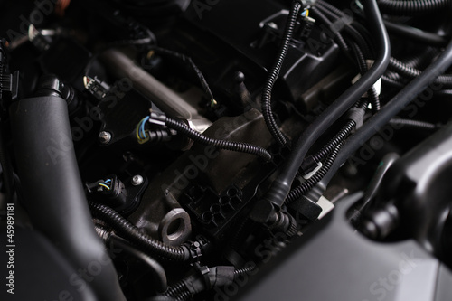 Closeup of electronics and engine under hood of car