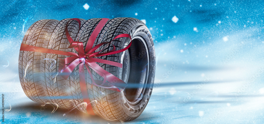 Car tires tied with red ribbon on colored background Car tires tied with red ribbon on colored background