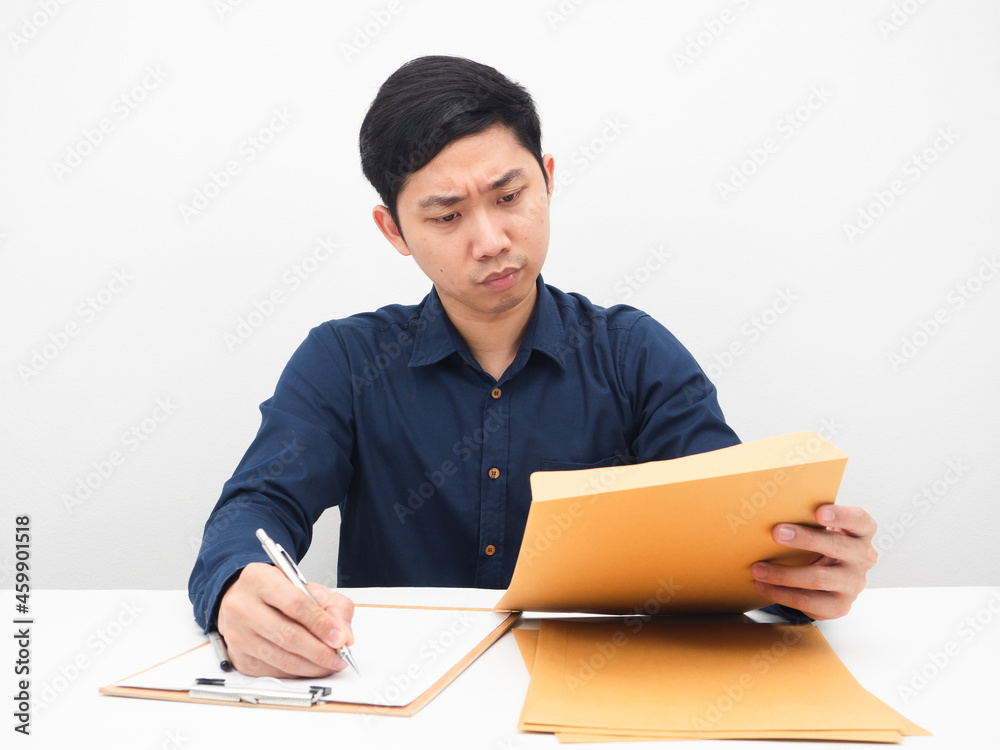 Man working at his workplace looking at document in hand feeling serious and strain white backgound Man working at his workplace looking at document in hand feeling serious and strain white backgound