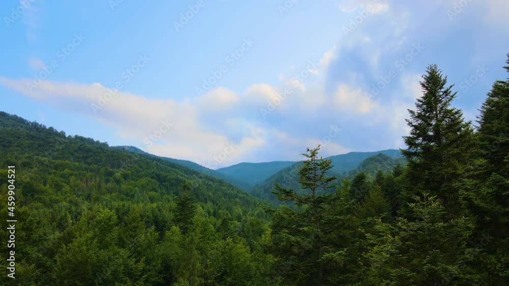 Aerial view of mountain hills covered with dense green lush woods on cloudy evening. Aerial view of mountain hills covered with dense green lush woods on cloudy evening.