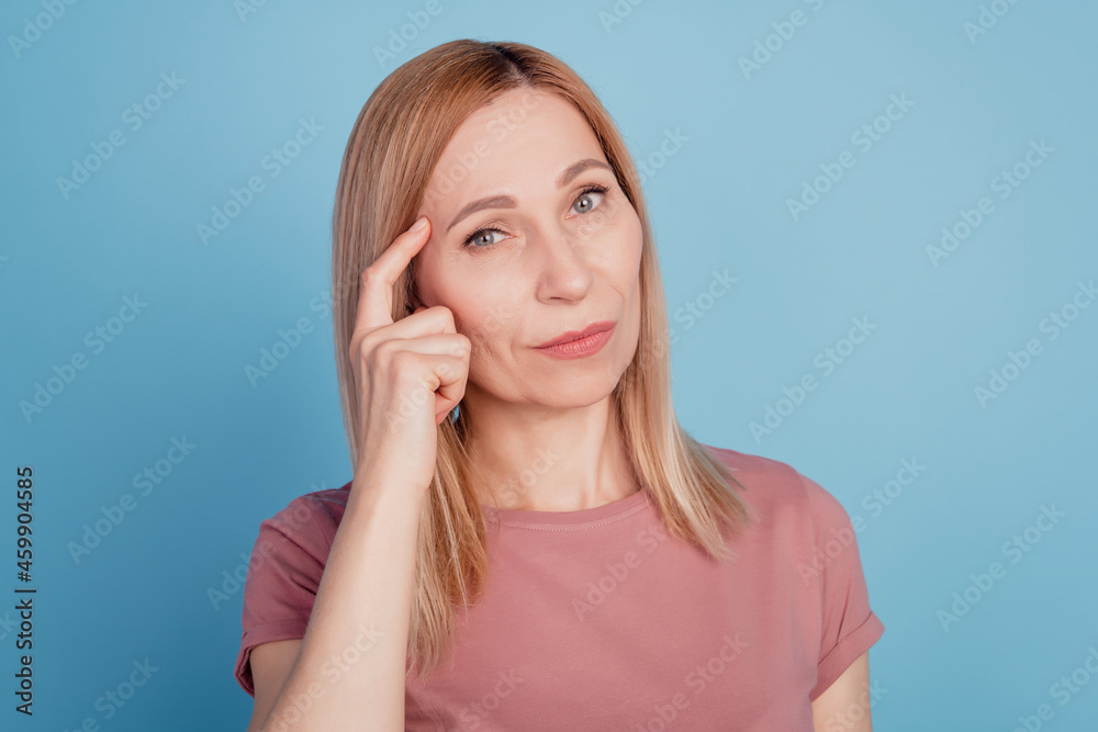 Close up portrait of pretty confident thoughtful girl finger touch head serious isolated over blue background Close up portrait of pretty confident thoughtful girl finger touch head serious isolated over blue background