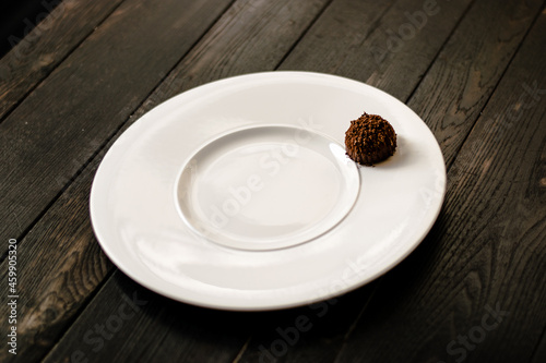 Chocolate truffle, single, on a plate at a restaurant