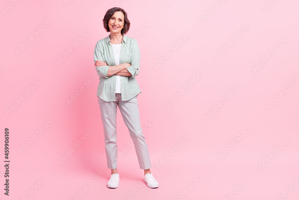 Full size portrait of positive candid aged person crossed arms have good mood isolated on pink color background Full size portrait of positive candid aged person crossed arms have good mood isolated on pink color background
