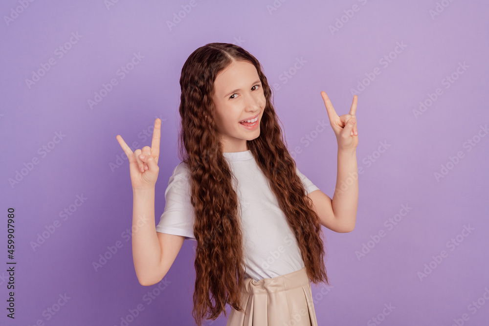 Photo of brown long haired cool girl make fingers rock symbol isolated on purple background Photo of brown long haired cool girl make fingers rock symbol isolated on purple background
