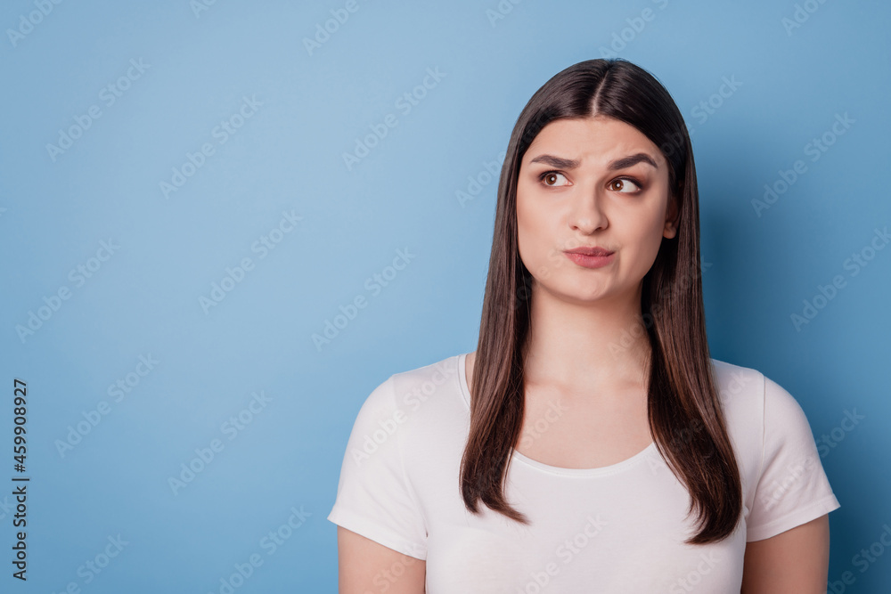 Portrait of interested uncertain lady look blank space have doubts on blue background