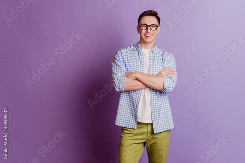 Portrait of self-assured confident guy crossed arms fit form on purple background