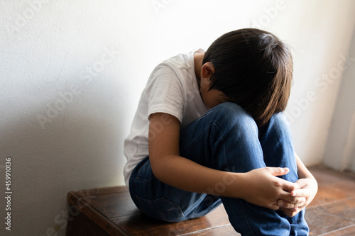 Little boy sitting in the corner of the house feeling sad from family problems